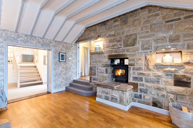 Spacious entrance hall with log burner and view of bedroom one