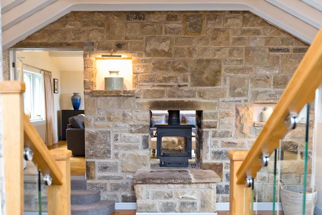 Spacious entrance hall with log burner and view of lounge