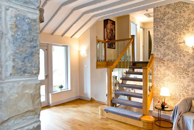 Spacious entrance hall with log burner and view of split level floors
