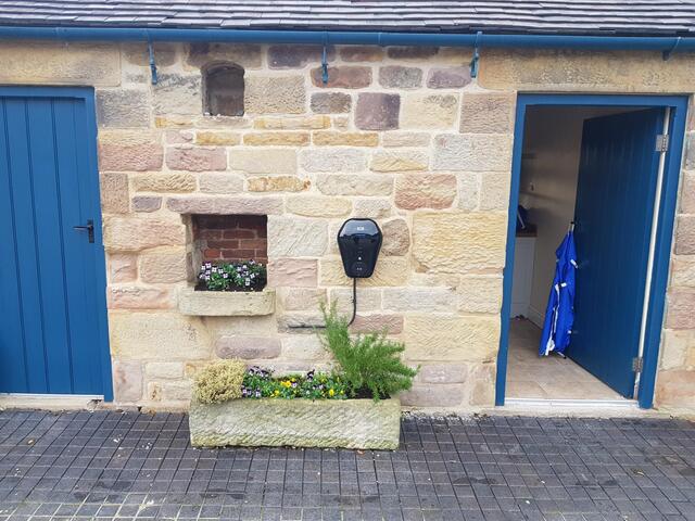 EV charger on the outbuilding wall in the courtyard