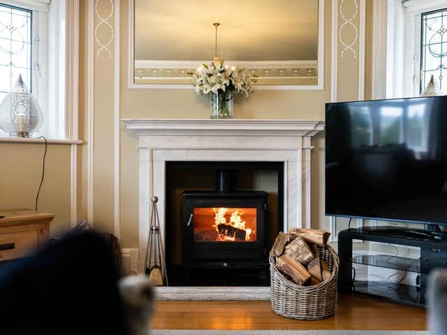 Log burner in The Drawing Room with basket of complimentary logs