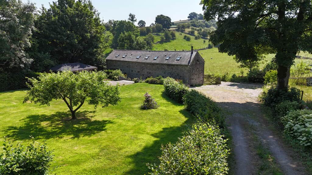 Image of the driveway to The Stables at Priestcliffe showing the rear garden and parking for up to 5 cars